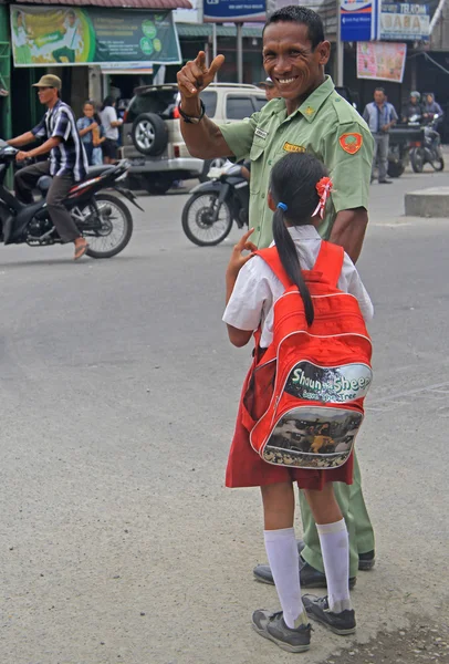 Oficial de policía con hija pequeña sonríe y muestra gesto de bienvenida — Foto de Stock