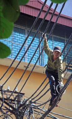 adam elektrik telleri tamir etmeye çalıştığını