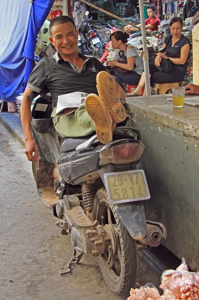 Az ember ül a motorkerékpár kinyújtott lábbal, Hanoi — Stock Fotó