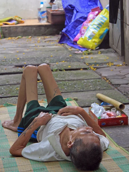 Evsiz sıska adam Hanoi kaldırımda yatıyor