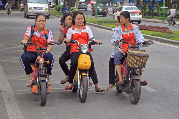 vietnamese girls are riding somewhere by motorcycle