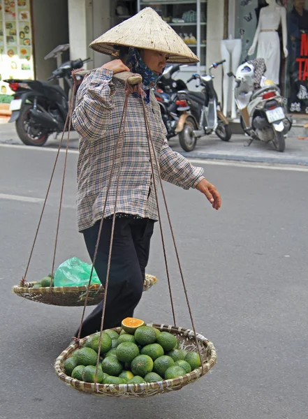 Donna sta portando braccio equilibrio con frutti — Foto Stock