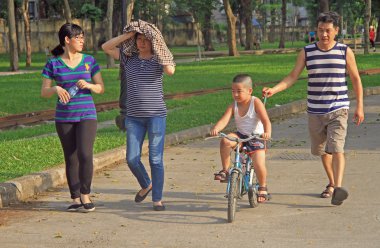 family of 4 peoples is walking in park, Hanoi, Vietnam