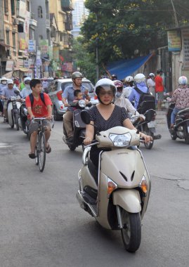 people are riding on motorcycles in Hanoi, Vietnam