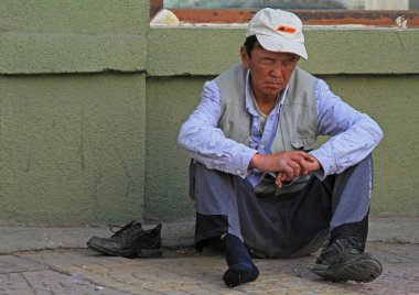 drunk man is sitting on asphalt in Ulaanbaatar