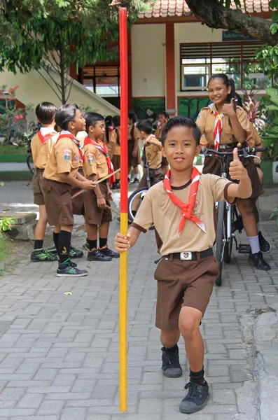 Boy is holding a stick and showing thumb on the street in Kuta, Bali — ストック写真