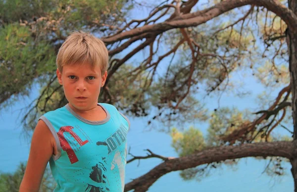 Boy with bloated nostrils against the background of sea — Stock Photo, Image