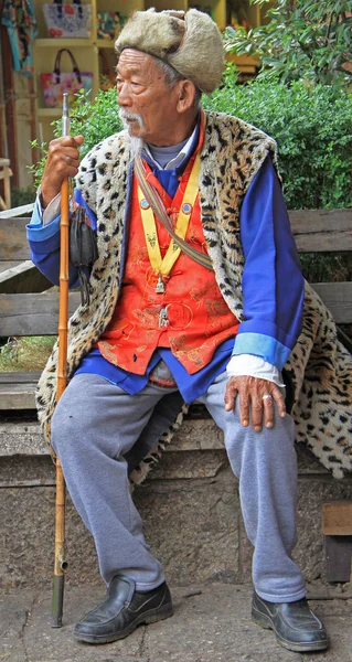 Homem velho está sititng em um banco, Lijiang, China — Fotografia de Stock