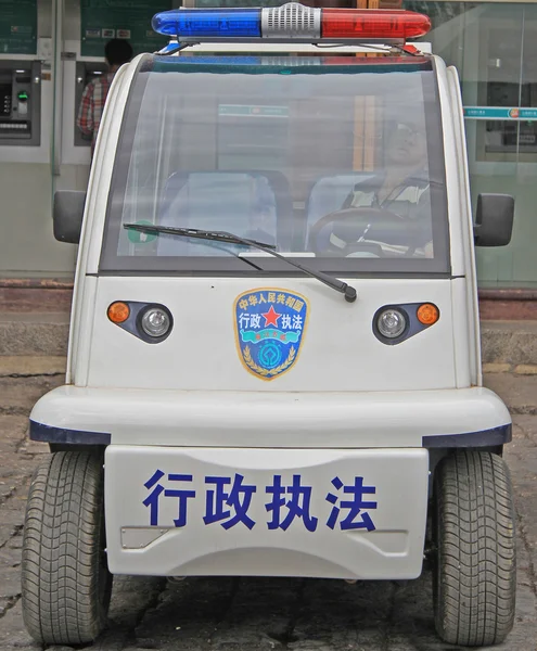 Oficial de policía está sentado dentro del coche en Lijiang, China — Foto de Stock