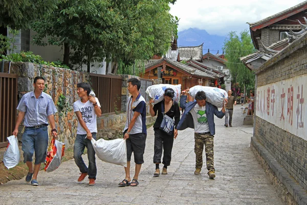 Homens estão carregando sacos em Lijiang — Fotografia de Stock