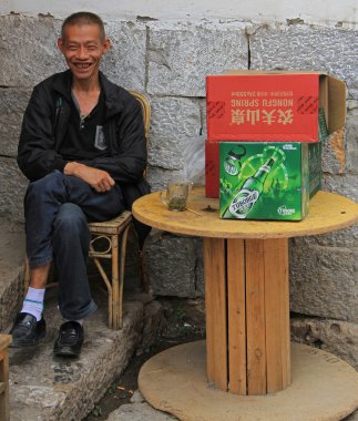 man is laughing on the street in Lijiang, China