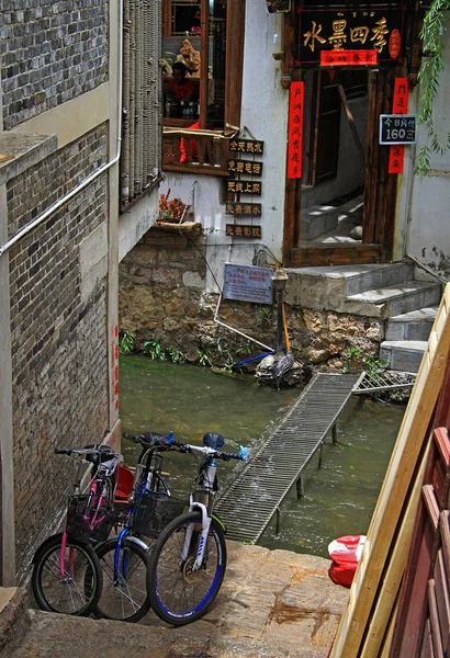 Few parked bicycle nearly canal on the street in Lijiang — Stockfoto