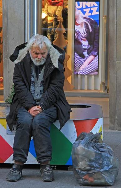 Senzatetto sta cercando di riscaldarsi per strada a Milano, Italia — Foto Stock