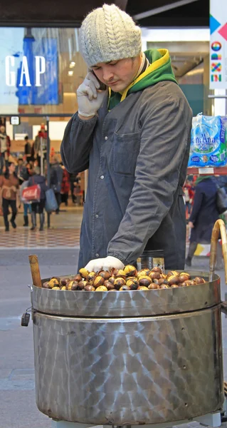 Hombre está vendiendo castañas en la calle en Milán —  Fotos de Stock