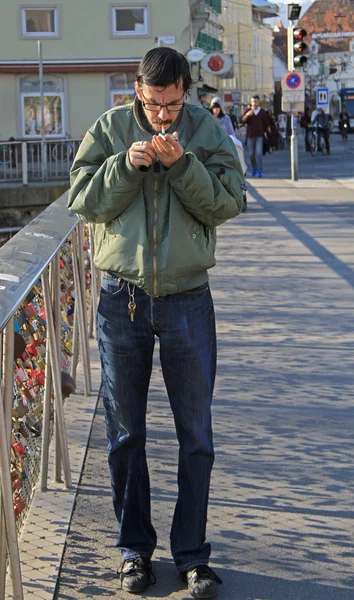 Hombre está encendiendo un cigarrillo en la calle en Graz, Austria —  Fotos de Stock