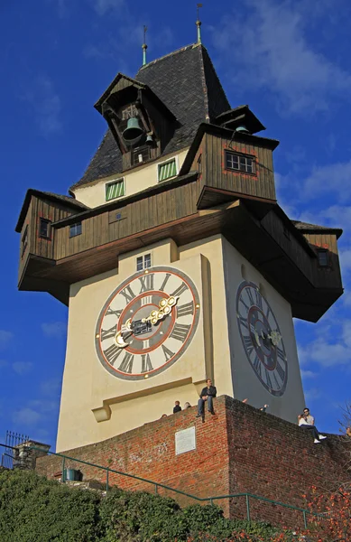 Pessoas estão sentadas perto da cidade Torre do relógio em Graz, Áustria — Fotografia de Stock