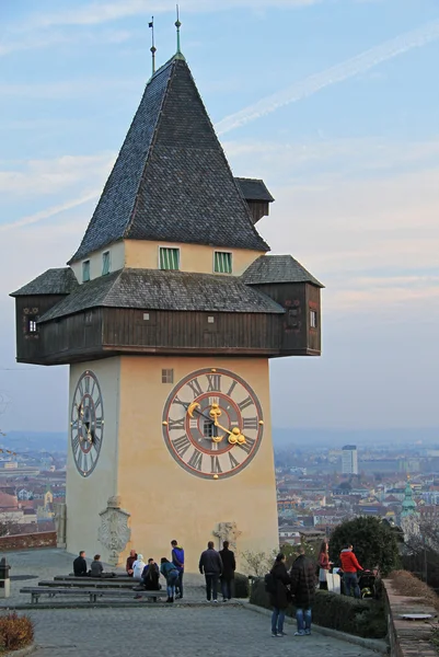 La gente está caminando casi torre del reloj de la ciudad en Graz, Austria — Foto de Stock