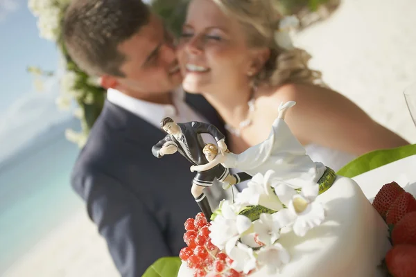 Casal lindo cortando bolo de casamento durante a cerimônia em tropical i — Fotografia de Stock