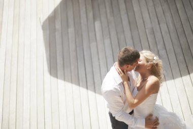 Lovely, gorgeous couple kissing close to pool area after wedding