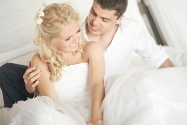 Lovely married couple teasing each other lying on bed.