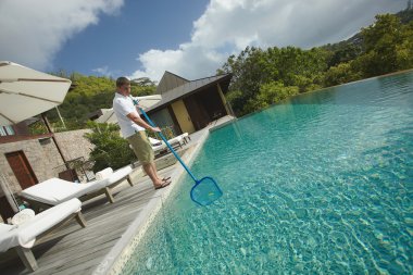 Swimming pool cleaner, professional cleaning service at work.