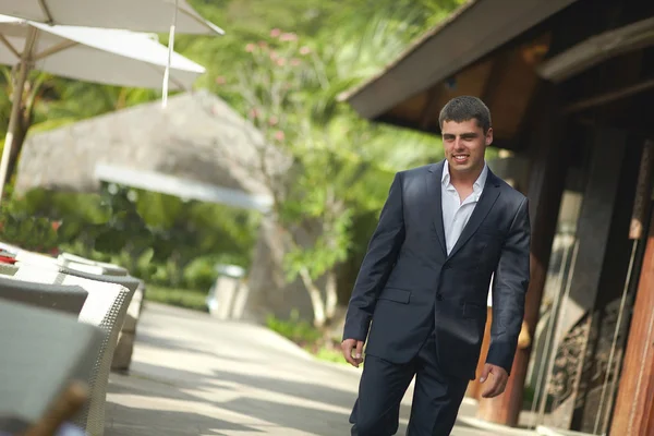 Yakışıklı genç adam teras karşısında restoran dışında yürüyüş. 