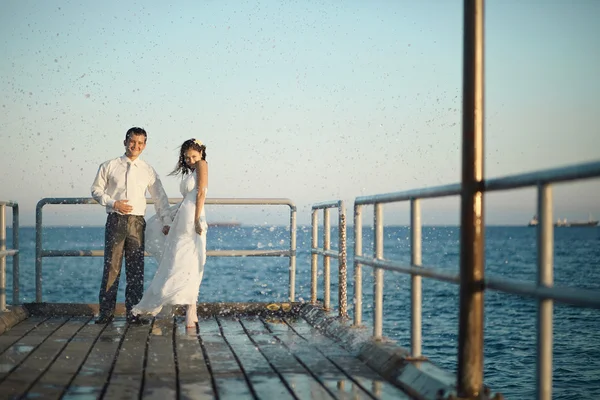 İskele, su sıçramalarına ve damla ile yürüyüş mesafesinde muhteşem Düğün çifti