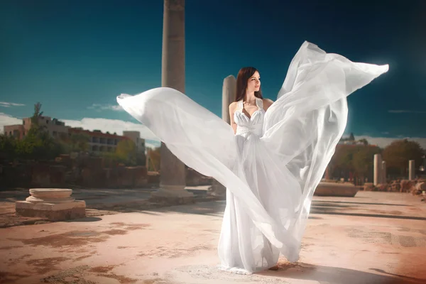 Ефірна, божественна наречена з літаючим, блискучим платтям, що стоїть в спокусі — стокове фото
