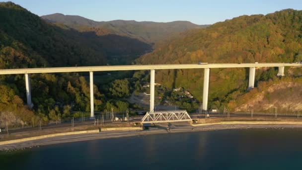 Hermoso puente grande para autopista a través del mar, vista aérea del giro del dron, hermoso diseño del puente automotriz en el mar. Viajar. Vuelo aéreo sobre el puente a medida que pasan los coches. Sochi, Rusia — Vídeos de Stock