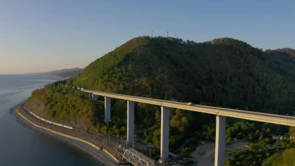 Hermoso puente grande para autopista a través del mar, vista aérea del giro del dron, hermoso diseño del puente automotriz. Viajar. Volando sobre el puente mientras pasan los coches. Sochi, Rusia — Vídeos de Stock