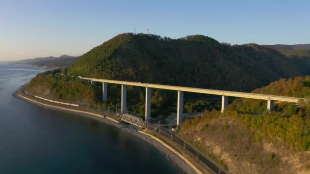 Gran puente para autopista a través del mar, vista aérea de giro de dron, diseño del puente automotriz en el mar. Viajar. Volando sobre el puente mientras pasan los coches. Sochi, Rusia — Vídeos de Stock