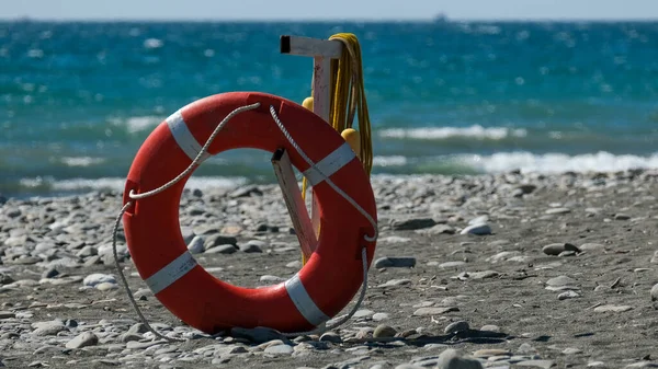 Orange lifebuoy on the beach. Safety on the water. Salvation. Coast guard. Rescuer. Drowning.