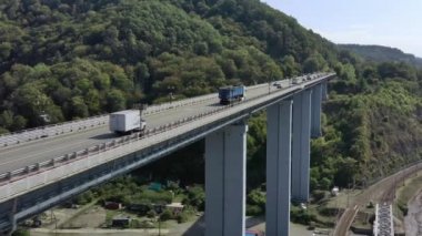 Güzel bir sahil yolu boyunca giden arabaların hava görüntüsü. Deniz kenarındaki kıyı şeridinin manzarası. Araba Geçidi olarak Köprü 'nün Üzerinde Uçmak. Soçi, Rusya