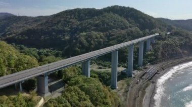 Güzel bir sahil yolu boyunca giden arabaların hava görüntüsü. Deniz kenarındaki kıyı şeridinin manzarası. Köprüden Araba Geçidi Olarak Uçmak. Sochi, Rusya. Yukarıda.. 