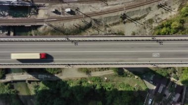 Havadan aşağıya manzaralı araba sürüşü. Sinema robotu yolda uçuyor. Köprünün Üstten Aşağı Hava Görüntüsü Deniz ve Araç Üzerinde Devam Ediyor. 