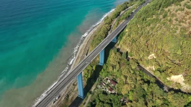 Aerial top down 4k widok jazdy samochodem. Zdjęcia drona lecącego nad drogą. Widok z góry na dół na most nad morzem i pojazd poruszający się po drogach. — Wideo stockowe