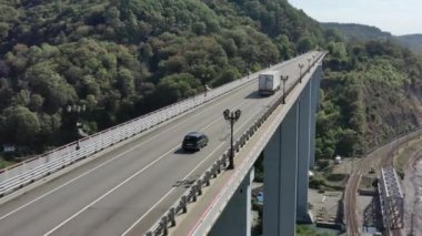 Güzel bir sahil yolu boyunca giden arabaların hava görüntüsü. Deniz kenarındaki kıyı şeridinin manzarası. Araba Geçidi olarak Köprü 'nün Üzerinde Uçmak. Soçi, Rusya