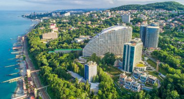 Soçi 'deki mavi Karadeniz kıyısında yaz gökyüzü altında evleri var. Kumsal. Deniz kenarındaki modern evler ve oteller.