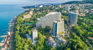Soçi 'deki mavi Karadeniz kıyısında yaz gökyüzü altında evleri var. Kumsal. Deniz kenarındaki modern evler ve oteller.