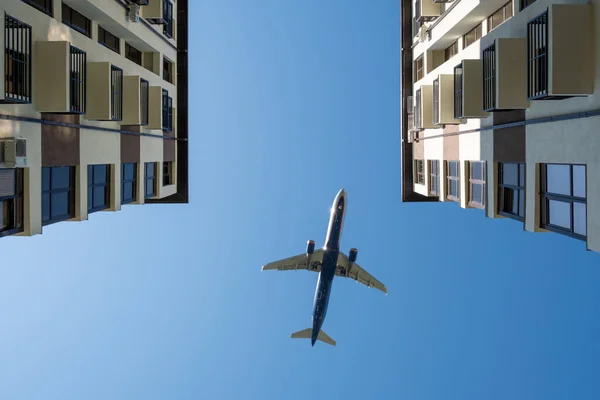 Passenger plane over house. airplane is flying over building. bottom view — Stock Photo, Image