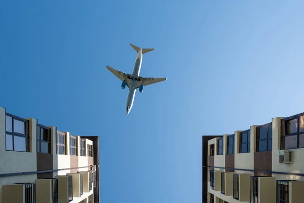 一架大型客机飞过房子。飞机在大楼上空盘旋. — 图库照片