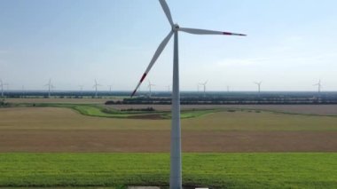 Elektrik üreten rüzgar türbinleri. Rüzgâr değirmeni güç teknolojisi. Enerji Üretiminde hava aracı görüntüsü. Rüzgâr türbinleri yeşil bir alanda duruyor. Kapat.. 