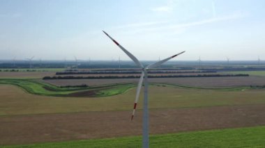 Elektrik üreten rüzgar türbinleri. Rüzgâr değirmeni güç teknolojisi - Enerji Üretiminde hava aracı görüntüsü. Rüzgâr türbinleri çiçek açan bir arazide duruyor. Yeşil alan. Kapat.. 