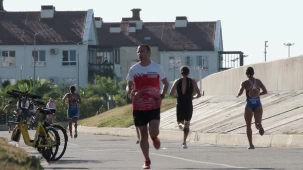 Sochi, Ryssland - 20 aug 2020: Unga människor en kille och en flicka är engagerade i idrott. Springer. Aktiv hälsosam livsstil. Vilken sport. God morgon, joggingtur. Idrottsform. — Stockvideo