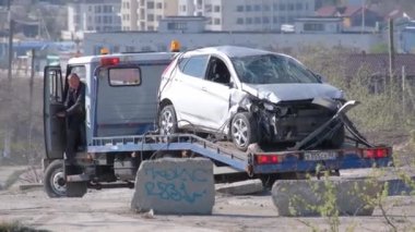 Bir vinç enkaz halindeki arabayı derin bir delikten çıkardı. Tahliye memuru. Kazanın kurbanı. Olay var. Sigorta olayı.
