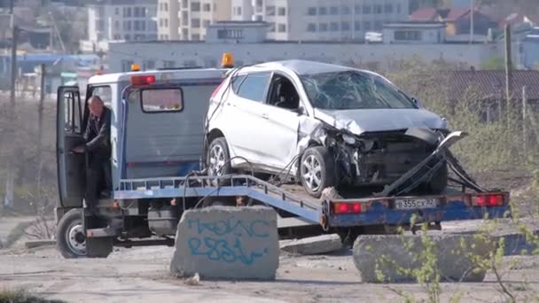 Ένας γερανός έβγαλε το τρακαρισμένο αμάξι από μια βαθιά τρύπα. Εκκένωση. Το θύμα του ατυχήματος. Περιστατικό. Ασφαλιστική εκδήλωση. — Αρχείο Βίντεο