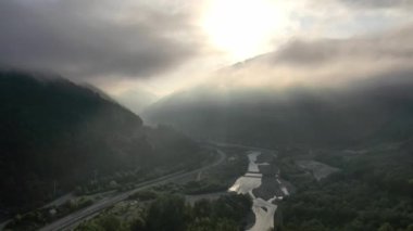 Dağların tepesinde bulutlar arasında uçuyor. Yüksek tepeler harika bir sabah doğumu manzarası. Soçi, Rusya