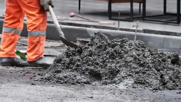 Építőmunkás keveri szürke cement holding lapát a földön lassított felvétel közeli. — Stock videók