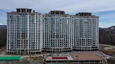 Çok uzun bir apartman dairesinin ön cephesine yaklaşan bir hava atışı. Soçi, Rusya