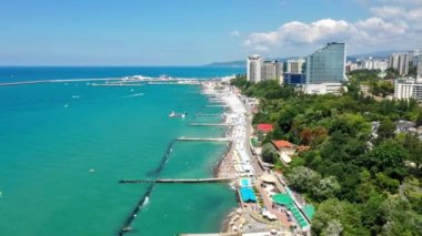 Air Sochi Rusya şehir merkezi gökdeleni tatil beldesi sahil liman dolumu. Karadeniz mavi suyu. Dağ doğal manzarası yaz güneşli gün bulutları